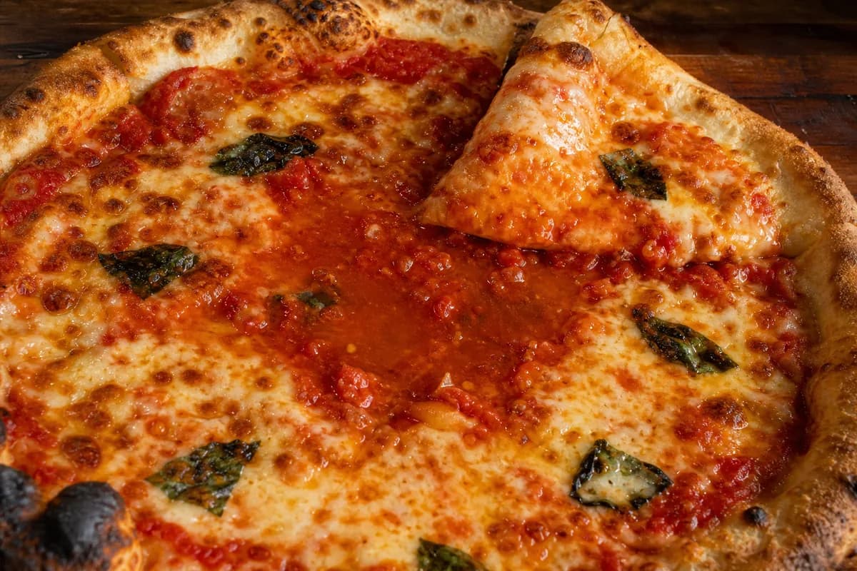 Pizza center left wet because sauce and toppings added too much moisture.